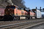 Vehicle train rolls west past grain train